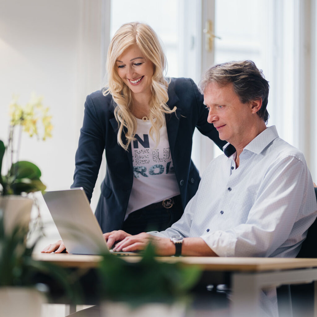 Zwei Menschen schauen gemeinsam auf den Laptop